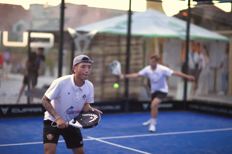 Zwei Padelspielers bei Aufschlag und am Netz